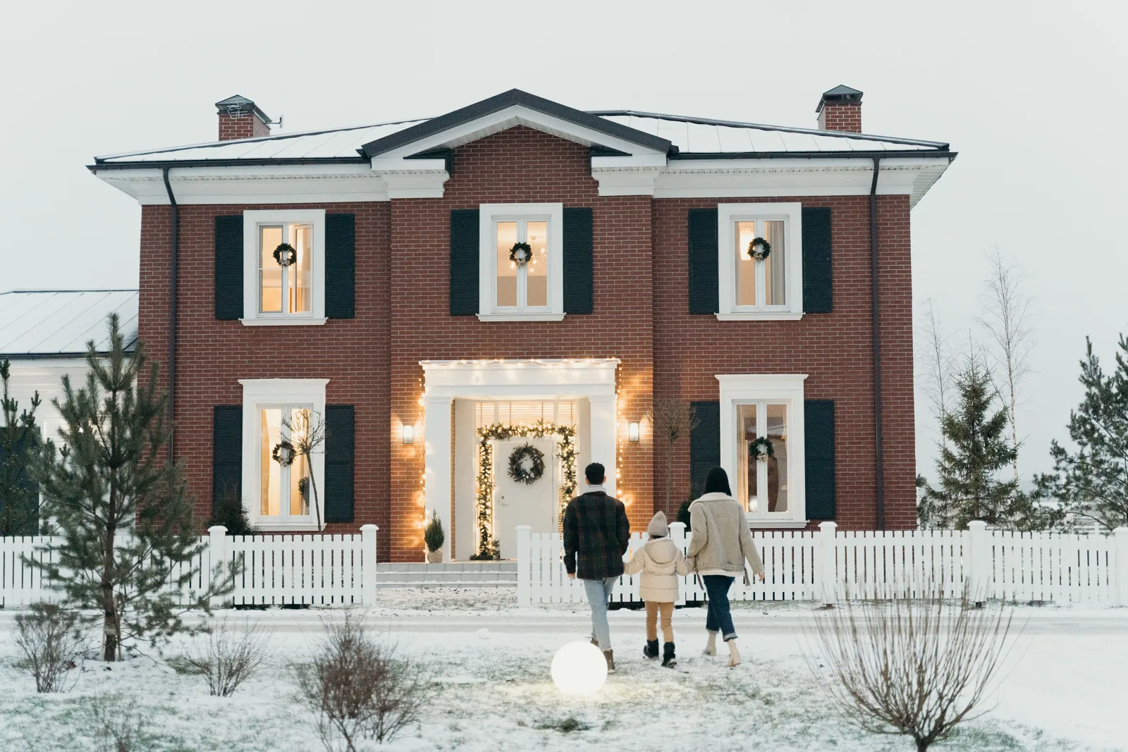 Famille devant sa maison en hiver