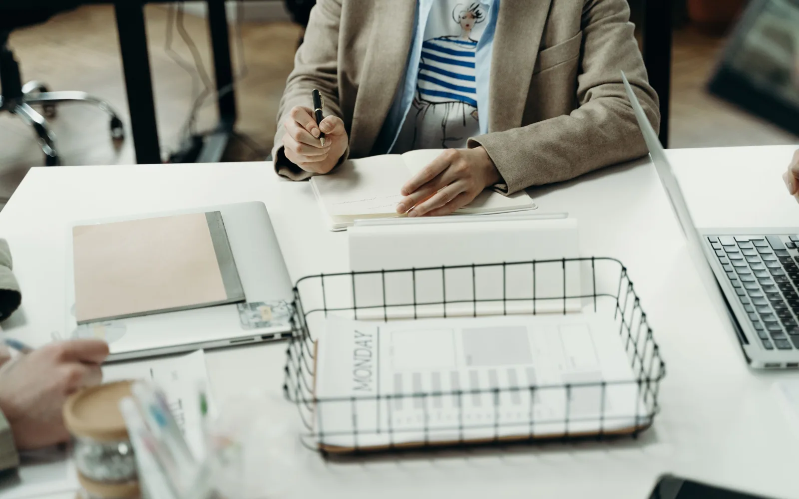 À la rédaction, une spécialiste annote un carnet, stylo en main